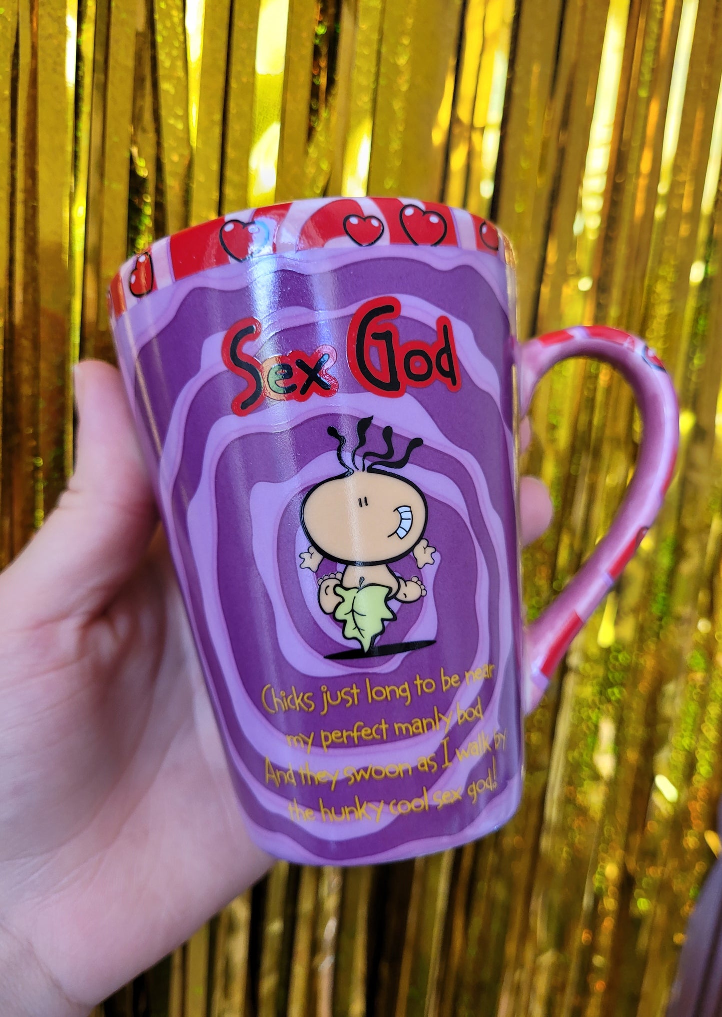 The back of the mug with a picture of the 'sex god' character featuring the poem underneath: 'Chicks just long to be near my perfect manly bod And they swoon as I walk by the hunky cool sex god'