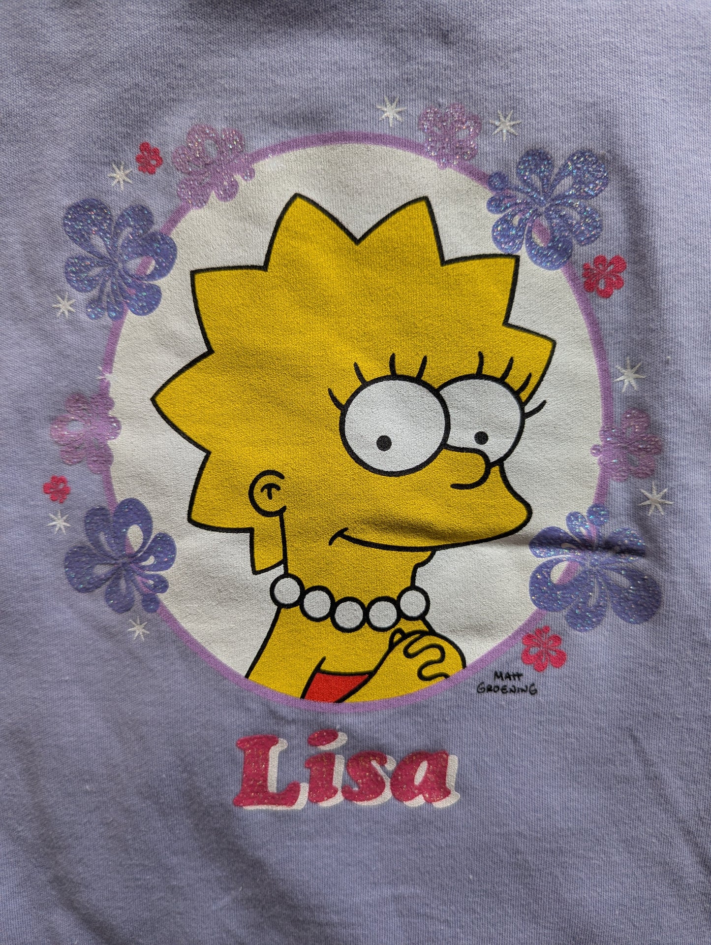 Lisa Simpson design on pyjama top: Lisa smiling inside a pink and purple floral border