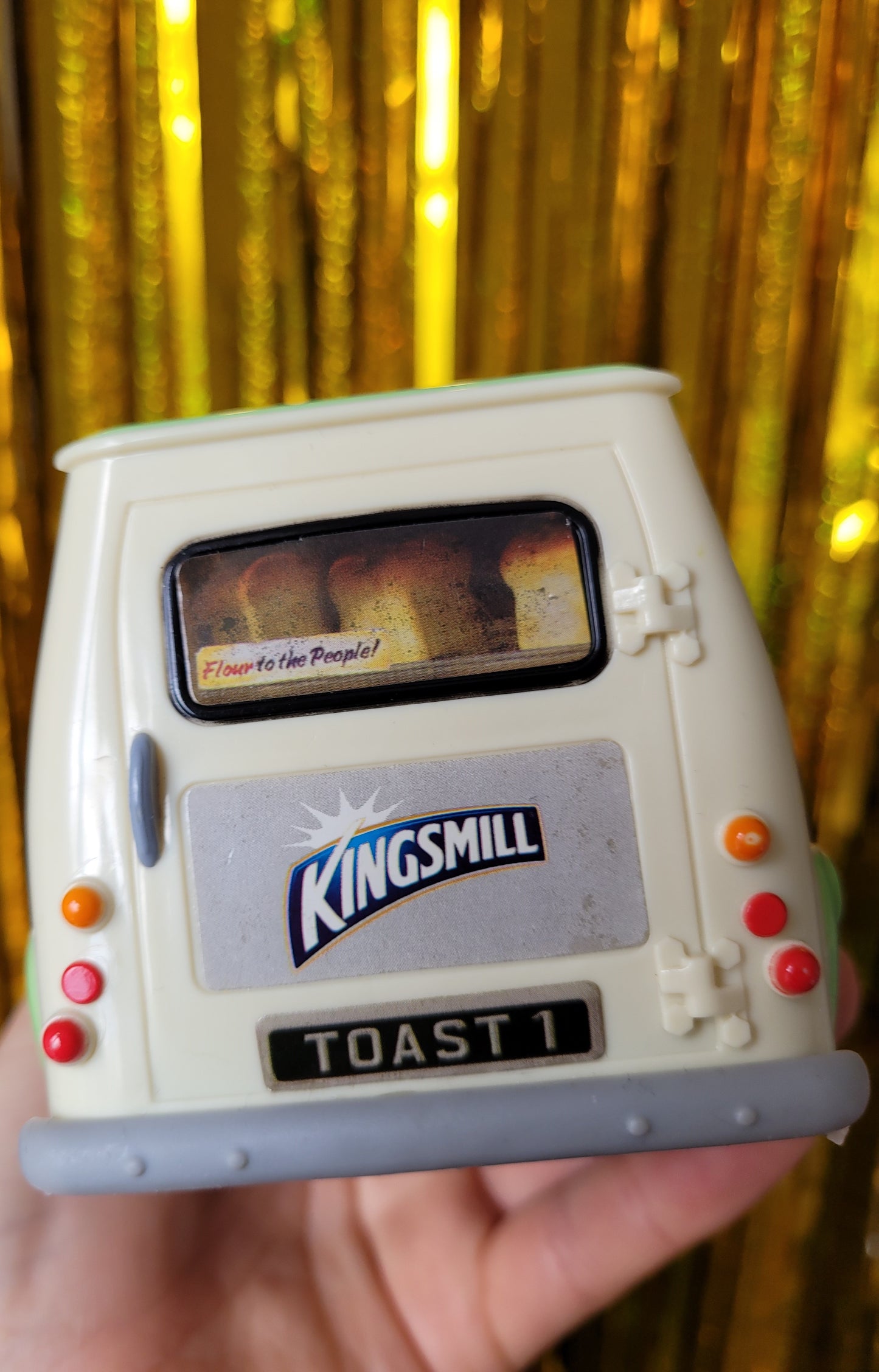 Back of the van. The sticker is water damaged with some dark water marks. The sticker depicts the back windscreen and has loaves of bread on it and a sticker in the window that says 'Flour to the people' 