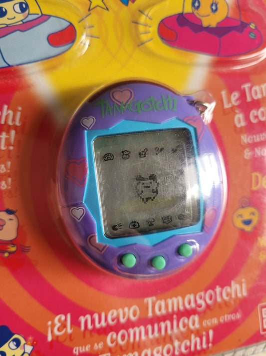 Close up of tamagotchi purple with pink hearts and a blue border around the screen and turquoise buttons