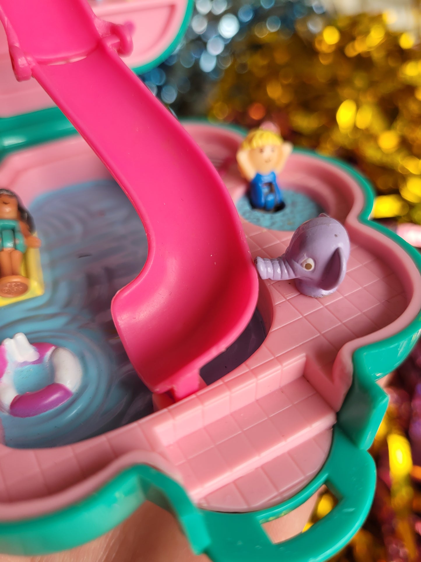 Close up of daisy figurine in the hot tub with a purple elephant water feature in the foreground