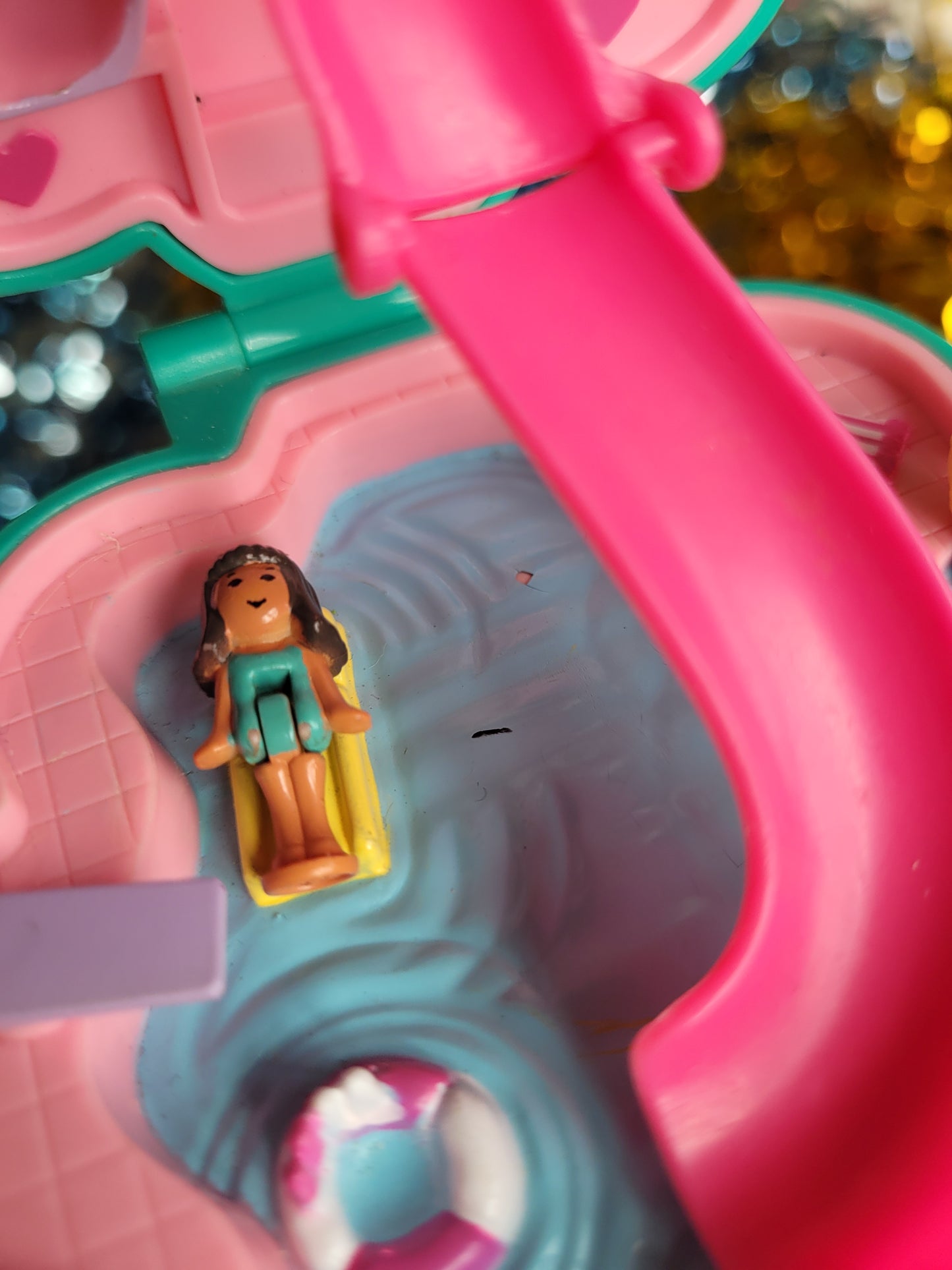 Close up of toy figurine minny lying on a lilo in the pool. Small chip in the pool surface. 