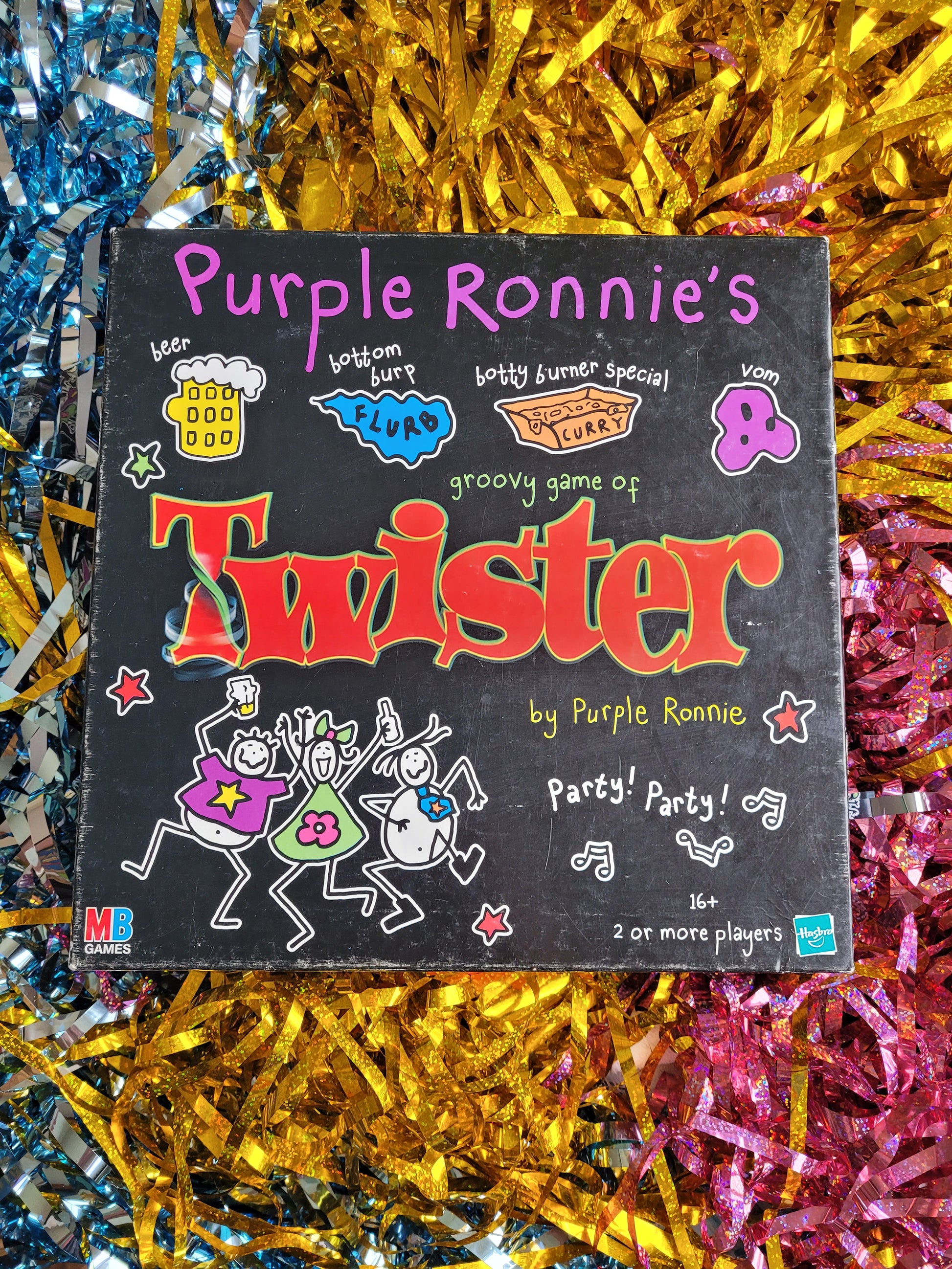 Front of Purple Ronnie twister box. With purple Ronnie characters drinking dancing in colourful clothes 