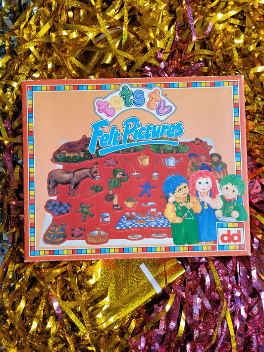 Colourful tots tv fuzzy felt box against a glittery tinsel background