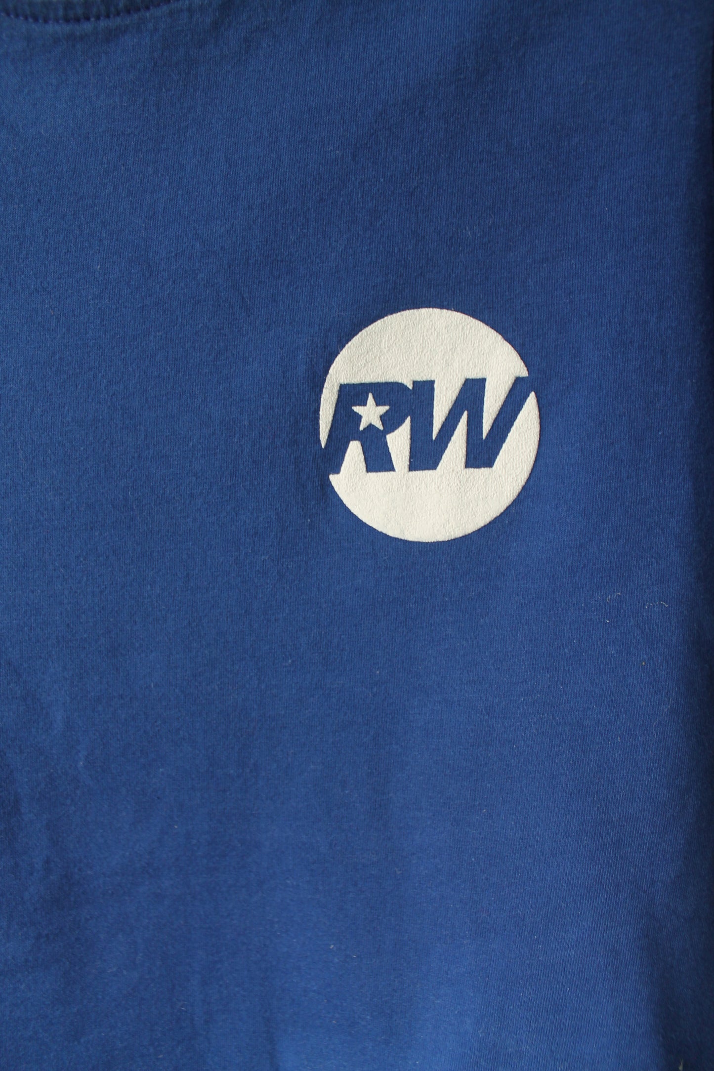 Closeup of the RW white logo on the blue shirt