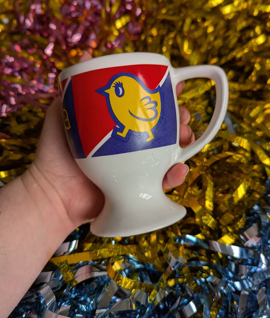 White creme egg mug with yellow, purple and red chick logo