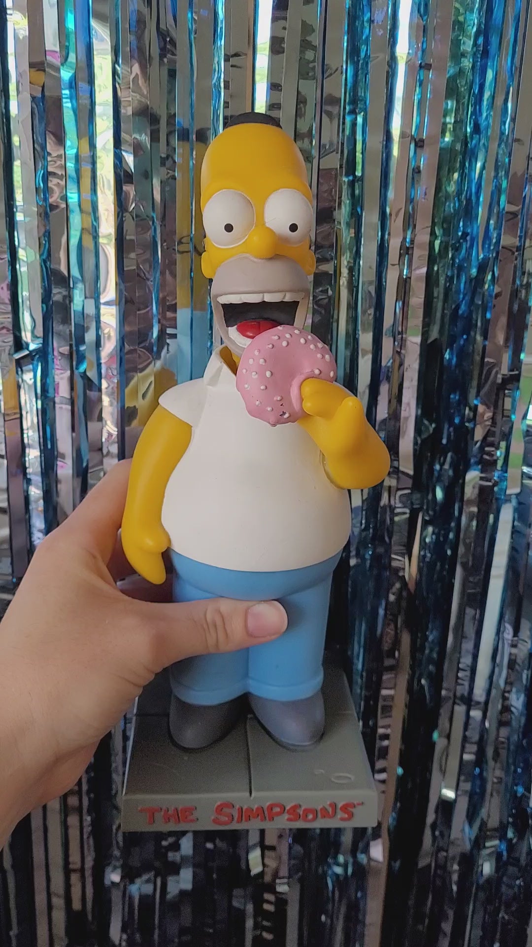 Homer bobblehead nodding back and forth looking like he's taking bites out the donut